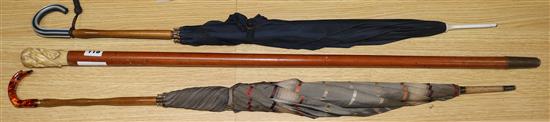 An ivory handled walking stick and 2 umbrellas